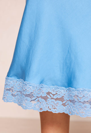 Close up shot of a blue skirt with lace trim.