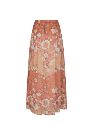 a-long-pleated-maxi-skirt-in-a-warm-peach-orange-color-featuring-a-large-scale-floral-pattern-in-cream-pink-and-light-purple-shown-against-a-plain-white-background