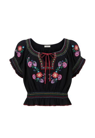 A black short-sleeve blouse with colorful floral embroidery, a red tie-neck bow, and a ruffled hem, shown against a plain white background.