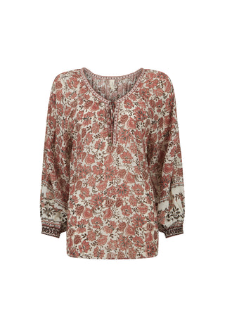 A long-sleeve bohemian-style blouse with a dense floral and paisley print in dusty rose, terracotta, and dark brown on a cream background, featuring a split neckline with tie details.