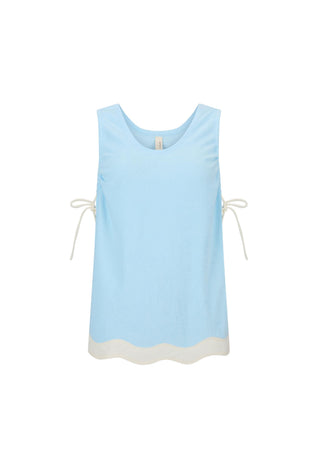 A light blue sleeveless top with a scalloped cream hem and cream tie details on the sides, displayed against a solid white background.