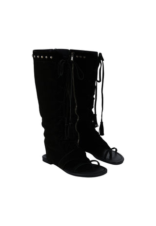 A pair of black knee-high boots with front lace-up detailing and small metallic studs near the top, shown against a plain white background.